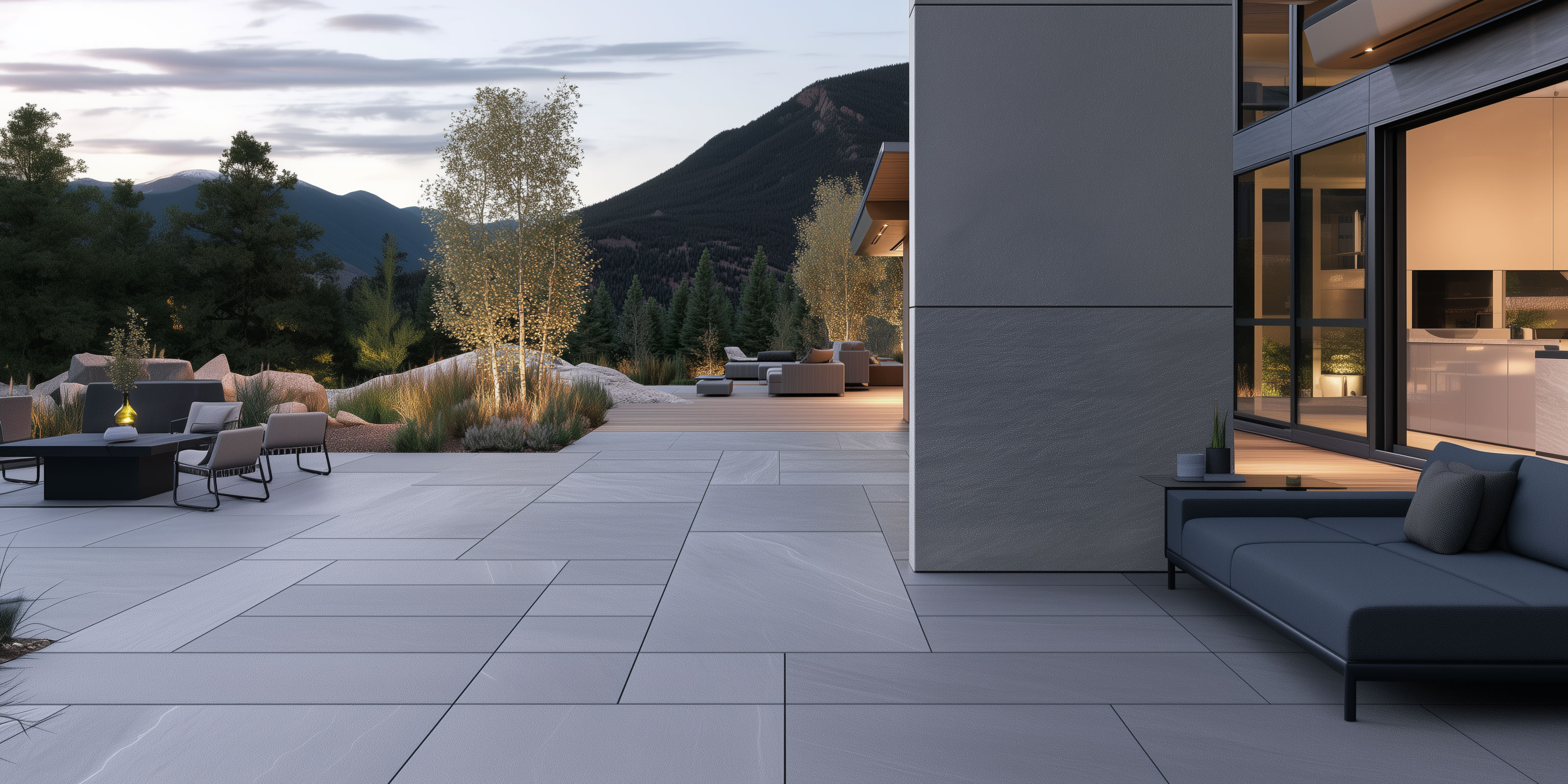 Modern courtyard paved in large-format gray pavers with lounge seating, a fire pit and aspen trees