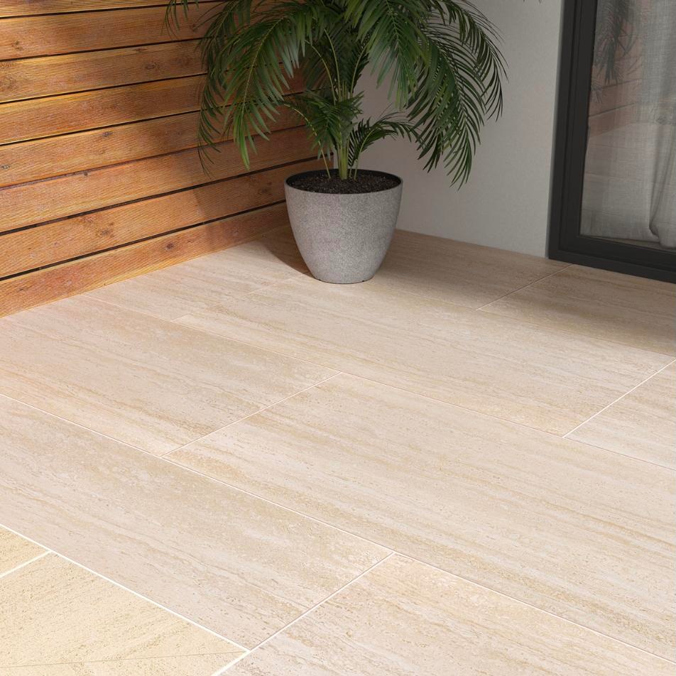 Travertine-look porcelain pavers on a patio beside a potted palm